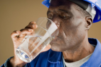 Exhausted worker drinking water: WorkingManLaw Workplace Safety Blog